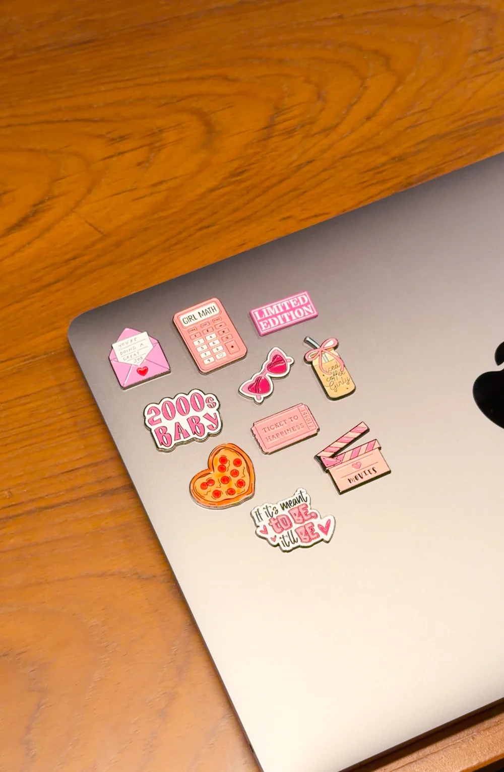 Pink Poplet enamel stickers on a silver laptop